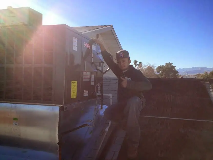 HVAC technician performing HVAC Inspection on a rooftop unit in Provo